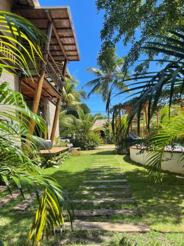 a path in front of a house with palm trees at Maui Maui Wellness- Taipu de Fora in Barra Grande