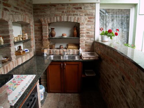 a kitchen with a sink and a brick wall at Péterfia Panzió in Debrecen