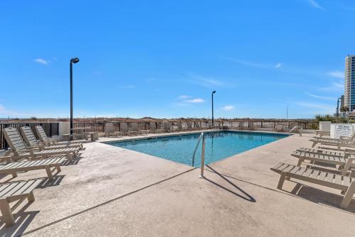 a swimming pool with chairs and a row of lights at Island Winds East Unit 401 in Gulf Shores