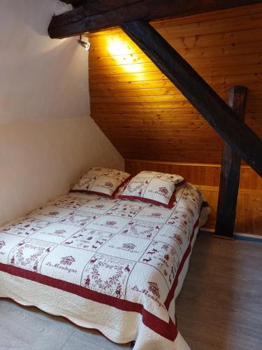 a bed in a room with a wooden ceiling at Les Marmottes in Les Étalons