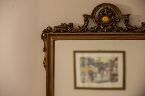 a gold picture frame on a wall with a picture at Affittacamere San Teodoro in Albenga