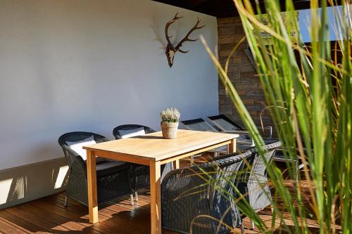 a wooden table with chairs and a potted plant on it at Schittlerhaus in Oberstdorf