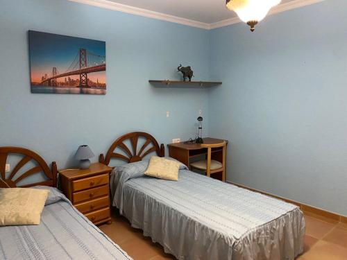 a bedroom with two beds and a bridge on the wall at Villa Ana in Romilla