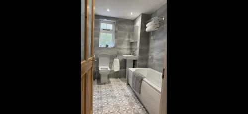 a bathroom with a tub and a toilet and a sink at Listed sword makers cottage in Shotley Bridge in Consett