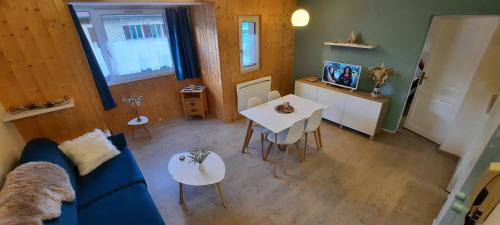Una sala de estar con un sofá azul y una mesa. en Au Coeur de Prémanon, en Prémanon