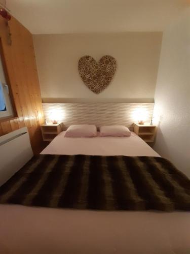 une chambre avec un lit avec un cœur sur le mur dans l'établissement Au Coeur de Prémanon, à Prémanon