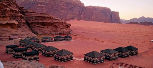 a row of parked cars on top of a sandy beach at Beyond Wadi Rum Camp in Wadi Rum