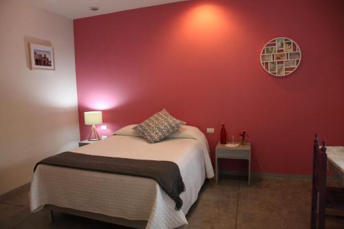 a bedroom with a bed and a red wall at La Betulia Bed and Breakfast in Oaxaca City
