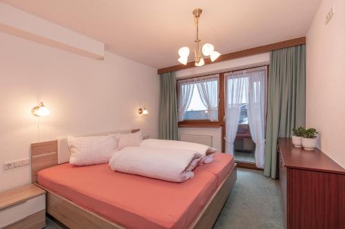 Schlafzimmer mit einem Bett und einem Fenster in der Unterkunft Appartementhaus Längenfeld in Längenfeld