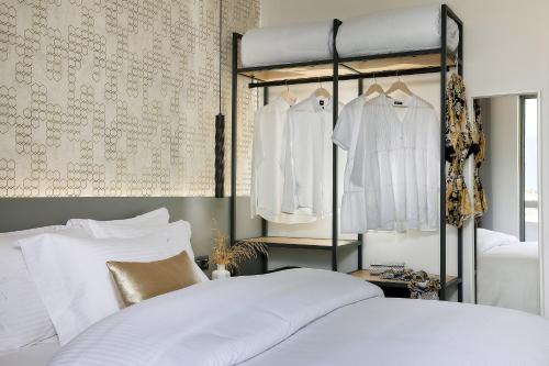 a bedroom with a bed with white clothes on hangers at Stay 365 Heraklion Apart Hotel in Heraklio Town
