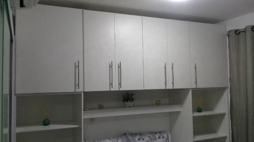 a white kitchen with white cabinets in a room at Flat Smart 401-Frente a praia-com self-check-in. in Salvador