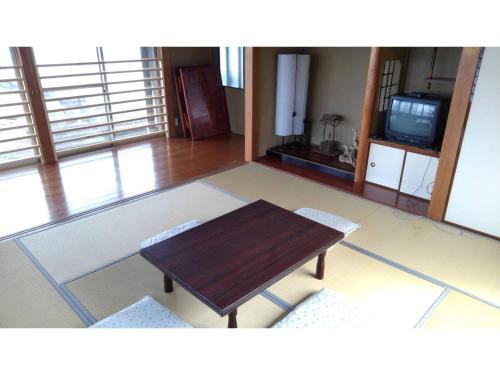 sala de estar con mesa de madera y TV en Sasayakana Ouchi Iso Takeoka Futtsu - Vacation STAY 80771v en Iwase