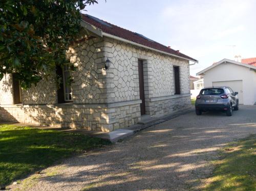 un'auto parcheggiata di fronte a un edificio in pietra di les hortensias a Saujon