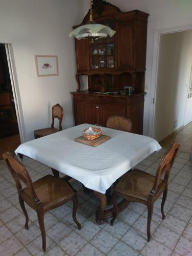 - une table à manger avec une nappe et des chaises blanches dans l'établissement les hortensias, à Saujon