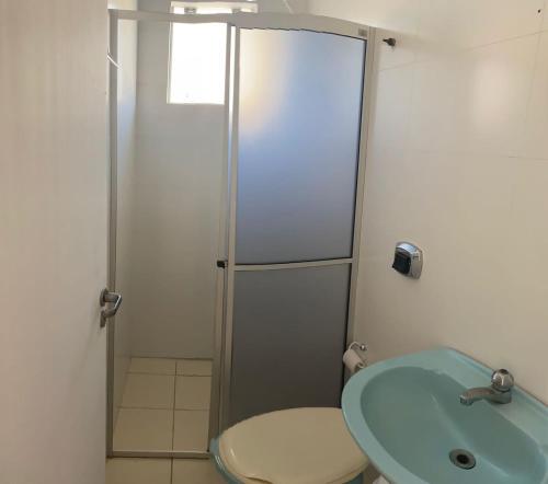 a bathroom with a shower and a toilet and a sink at AP frente à praça bem localizado in São José