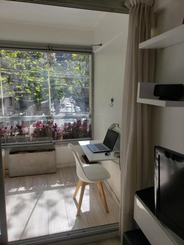 ordenador portátil con mesa en una habitación con ventana en Alto Palermo en Buenos Aires