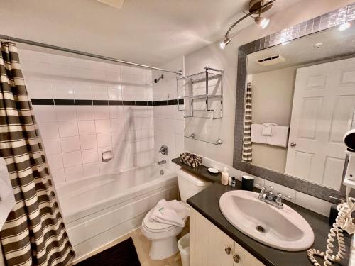 a bathroom with a sink and a tub and a toilet at Best ski in ski out condo at Whistler in Whistler