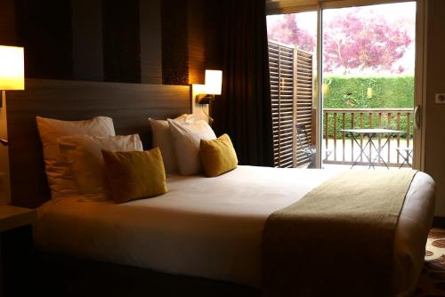 Un pat sau paturi într-o cameră la Contact Hôtel Le Provençal Bordeaux Lac