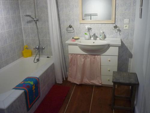 uma casa de banho com um lavatório e uma banheira e um lavatório em Les hirondelles em Wangen