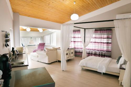 ein großes Wohnzimmer mit weißen Möbeln und Fenstern in der Unterkunft Chic Studio in Bukarest