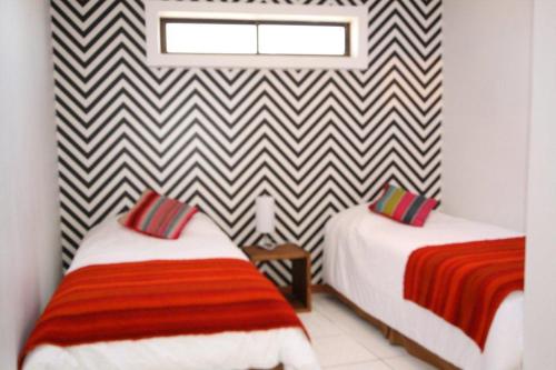 a room with two beds and a wall at Hotel Avenida en Arica in Arica
