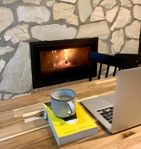 a cup of coffee sitting on a table next to a laptop at La Siesta del Naranjo in Monesterio