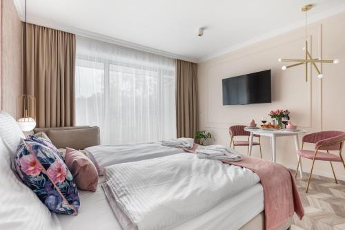 ein Schlafzimmer mit einem Bett und einem Tisch mit Stühlen in der Unterkunft Golden Line Apartments in Świnoujście