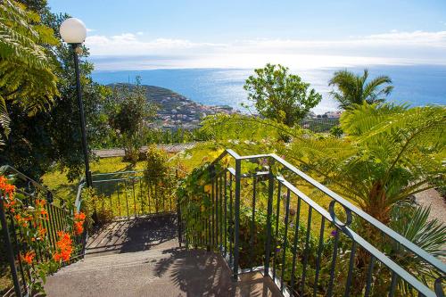 a staircase leading down to a view of the ocean at Vila Afonso in Estreito de Câmara de Lobos