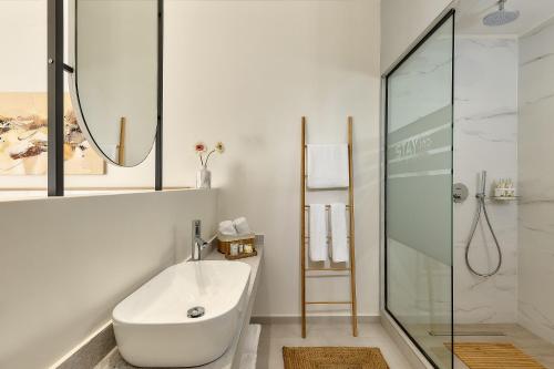a bathroom with a white tub and a glass shower at Stay 365 Heraklion Apart Hotel in Heraklio Town