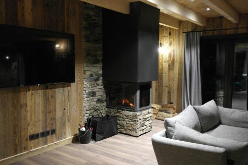 un salon avec un canapé et une cheminée dans l'établissement Maison de village au coeur d'Allos, à Allos