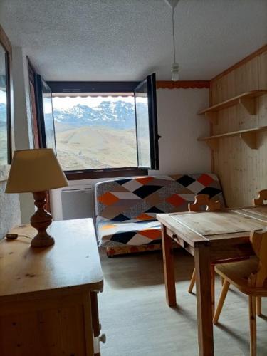 une chambre avec un lit, une table et une fenêtre dans l'établissement Résidence le Joker, à Val Thorens