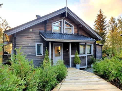 a house with a wooden walkway in front of it at Villa Laiskajaakko in Vimpeli