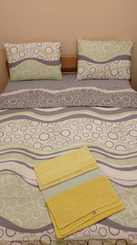 a bed with two blankets and pillows on it at Ino 99 in Užice