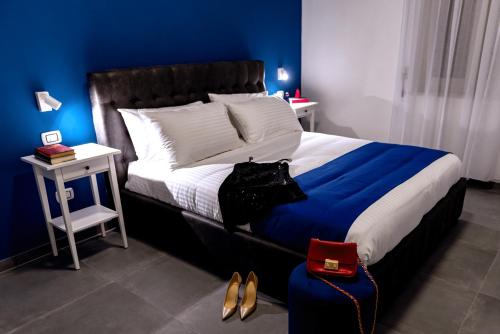 ナポリにあるNAPOLI IN BLU MAISONの青い壁のベッドルーム1室(大型ベッド1台付)