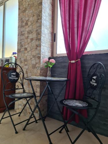 Domus Lace في مسينة: طاولة وكرسيين أمام النافذة