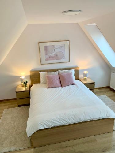 a bedroom with a large bed with pink pillows at APARTAMENT PIĘTROWY w centrum Kłodzka z darmowym parkingiem no 8 in Kłodzko
