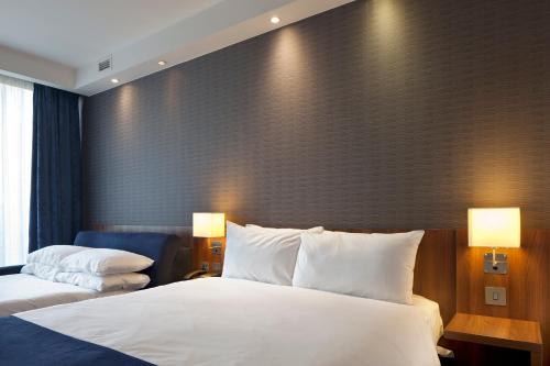 a hotel room with two beds and a large wall at Holiday Inn Express Manchester City Centre by IHG in Manchester