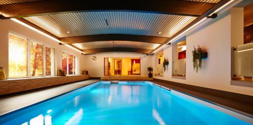 a swimming pool in a house with a ceiling at Wellnesshotel Zum Koch in Ortenburg