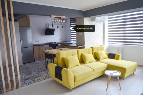 un soggiorno con divano giallo e una cucina di Apartment no 11 - Amarilia Apartments a Constanţa