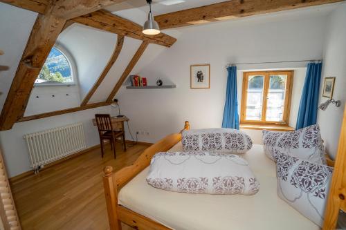 a bedroom with a bed with two pillows on it at Apartment Bügl Grond 124 in Scuol