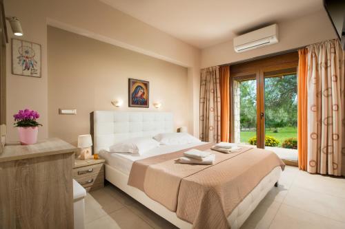 sypialnia z dużym łóżkiem i oknem w obiekcie Villa Elva Nafplio w Nauplionie
