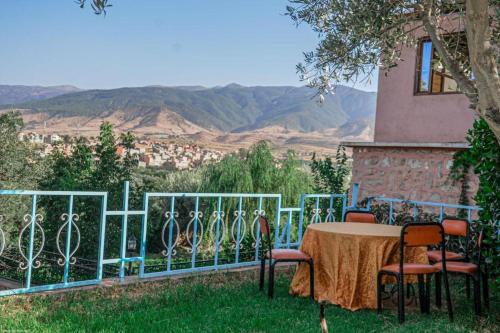 a table and chairs in front of a fence at L'oliveraie D'amizmiz in Amizmiz