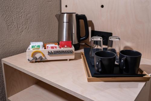 a counter with a coffee maker and glasses on it at La Meridiana in Costermano sul Garda