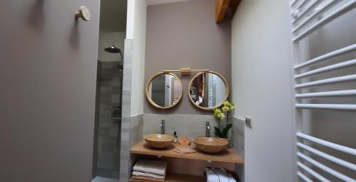 a bathroom with two sinks and two mirrors at Bel Aujourd'hui Spa Sauna in Cordelle