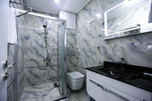 ein Bad mit einer Dusche, einem WC und einem Waschbecken in der Unterkunft RESTWON SUIT in Istanbul