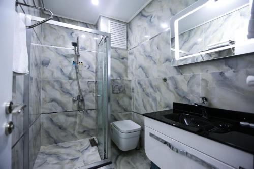 Un baño con ducha, inodoro y lavabo. en RESTWON SUIT, en Estambul