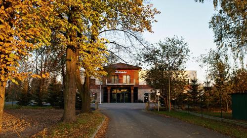 a building on the side of a road with trees at Jordaszka in Wodzisław Śląski