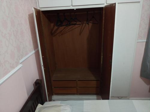a closet with a wooden door in a room at Quarto Familiar Aconchegante in Recife