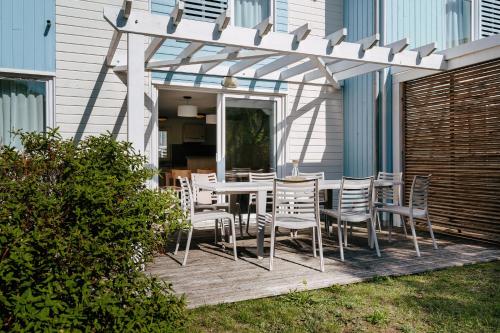 un patio con mesa y sillas en una terraza en Résidence Pierre & Vacances Le Domaine du Bois de la Grée en Pornichet