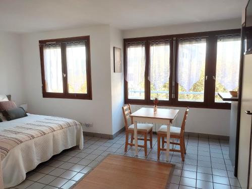 une chambre avec un lit, une table et des chaises dans l'établissement Joli Studio Tout Confort - Centre-ville, à Annecy